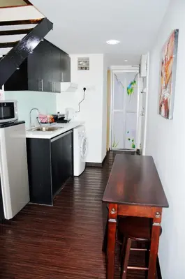 a small kitchen with a table and a sink at Taragon Residences in Kuala Lumpur