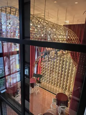 a view of a stage from a window with stools at Scarletz KLCC By AR Hospitality in Kuala Lumpur