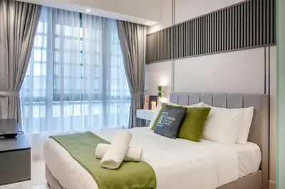 a bedroom with a large bed with green and white pillows at NOVO Ampang Modern Studio Infinity Pool near KLCC & Gleneagles in Kuala Lumpur
