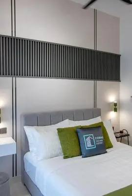 a bedroom with a white bed with green pillows at NOVO Ampang Modern Studio Infinity Pool near KLCC & Gleneagles in Kuala Lumpur