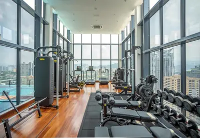 a gym with a lot of exercise equipment and windows at NOVO Ampang Modern Studio Infinity Pool near KLCC & Gleneagles in Kuala Lumpur
