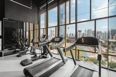 a gym with cardio machines and a view of the city at Blueground Kuala Lumpur city view nr KL Bird Park KUL-2 in Kuala Lumpur