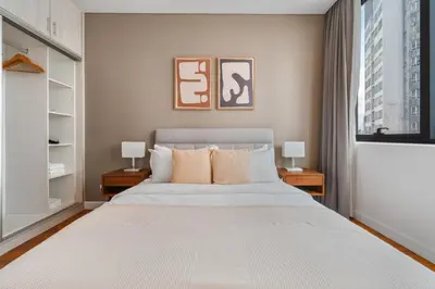 a bedroom with a large white bed with two lamps at Blueground Kuala Lumpur pool nr KL Tower KUL-5 in Kuala Lumpur