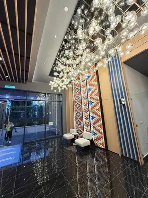 a lobby with chairs and a chandelier in a building at Majestic Residence KLCC By AFA in Kuala Lumpur