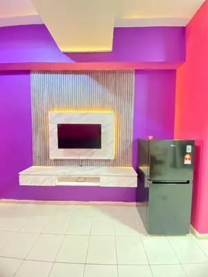 a colorful kitchen with a fireplace and a refrigerator at nuvea Suites in Kuala Lumpur