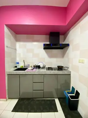 a kitchen with a sink and a pink wall at nuvea Suites in Kuala Lumpur