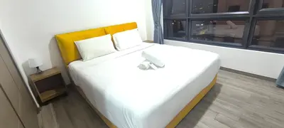 a bedroom with a large white bed with a yellow headboard at Agile Twilight Residence Apartment in Kuala Lumpur
