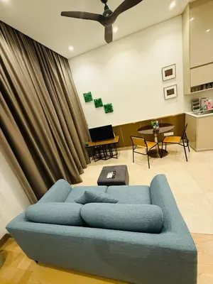 a blue couch in a living room with a piano at Lucentia Cozy Comfort Infinity Pool Suites in Kuala Lumpur