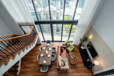 a living room with a table and a large window at Isola KLCC By Feel Home in Kuala Lumpur