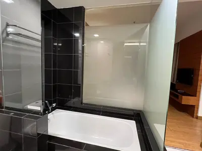 a bathroom with a tub and a glass shower at Suit Unit at Dua Sentral in Kuala Lumpur