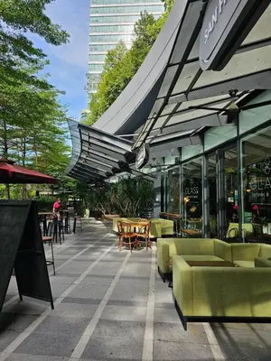 a patio with chairs and tables and umbrellas at Cozy Spacious Loft St Mary Bukit Bintang Pavilion in Kuala Lumpur