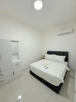 a white bedroom with a bed and a cabinet at Majestic Residence KL in Kuala Lumpur