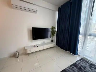 a living room with a flat screen tv on a wall at Majestic Residence KL in Kuala Lumpur