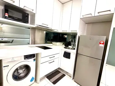 a kitchen with a washing machine and a microwave at Kuala Lumpur City Center By Summer Suites in Kuala Lumpur
