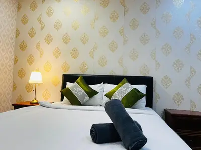 a bedroom with a white bed with green pillows at Kuala Lumpur City Center By Summer Suites in Kuala Lumpur