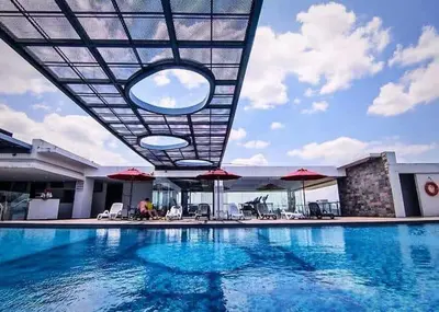 a swimming pool with chairs and umbrellas on a building at Super Tang Jaya in Kuala Lumpur
