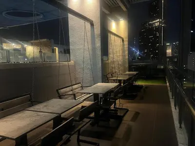 a row of tables and chairs on a rooftop at night at Super Tang Jaya in Kuala Lumpur