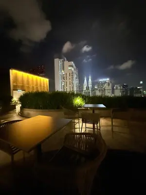 a city skyline at night with tables and chairs at Majestic Suites KLCC By Fortune in Kuala Lumpur