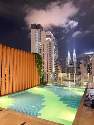 a large swimming pool with a city skyline in the background at Majestic Suites KLCC By Fortune in Kuala Lumpur