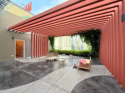 a red wall with chairs and tables in a courtyard at Majestic Suites KLCC By Fortune in Kuala Lumpur