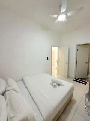 a white bed in a room with a ceiling fan at Majestic Serviced Suites KLCC in Kuala Lumpur