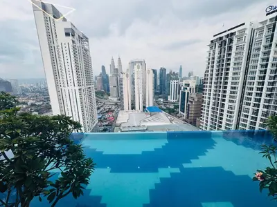 a swimming pool in the middle of a city with tall buildings at Majestic Serviced Suites KLCC in Kuala Lumpur