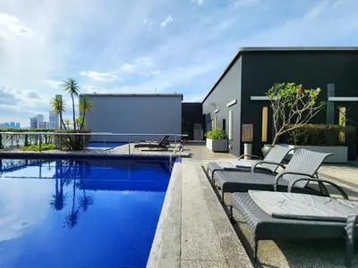 a swimming pool with lounge chairs next to a building at Kuala Lumpur Bintang Fairlane #107 TRX Pavilion KL in Kuala Lumpur