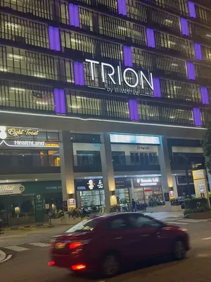 a car driving down a street in front of a building at Trion Homestay -KL in Kuala Lumpur