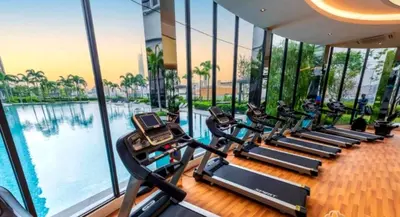 a gym with a row of treadmills next to a pool at Trion Homestay -KL in Kuala Lumpur