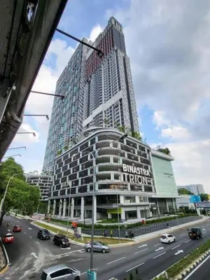 a tall building on a busy city street with cars at Trion Homestay -KL in Kuala Lumpur