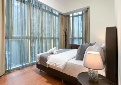 a bedroom with a bed and a table with a lamp at MARC Residence KLCC by VastHaven in Kuala Lumpur