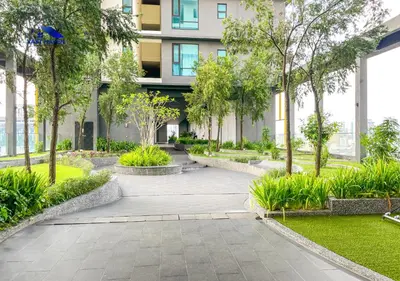 a walkway in front of a building with trees at OPUS Residences Kuala Lumpur by VastHaven in Kuala Lumpur