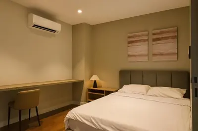 a bedroom with a bed and a chair and a air conditioner at Novo Ampang by Dormeo Destinations - Near KLCC and TRX in Kuala Lumpur