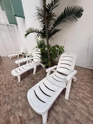 a group of white lounge chairs next to a palm tree at Mykl Family suite Taragon in Kuala Lumpur