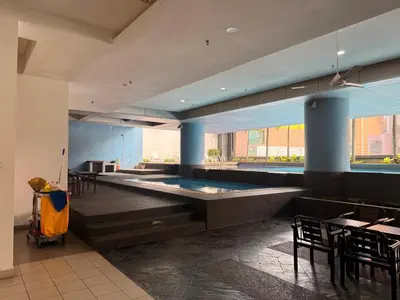 a swimming pool in a room with tables and chairs at Mykl Family suite Taragon in Kuala Lumpur