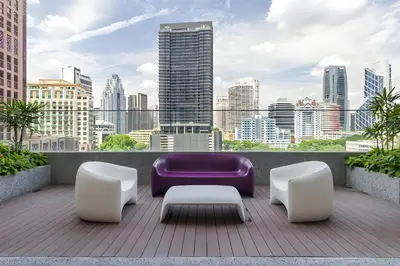 a balcony with a purple couch and white chairs at KLCC Quill Residences by Avery #Located in the City Center #10 mins walk to Twin Towers #Infinity pool#\u4e2d\u82f1\u6587\u623f\u4e1c in Kuala Lumpur