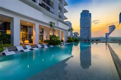a hotel pool with chairs and a city skyline at KLCC Quill Residences by Avery #Located in the City Center #10 mins walk to Twin Towers #Infinity pool#\u4e2d\u82f1\u6587\u623f\u4e1c in Kuala Lumpur