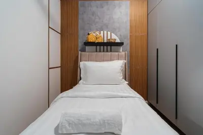 a bedroom with a bed with a wooden headboard at Ancestry 3BR M Vertica MRT Access by RumaBnB in Kuala Lumpur