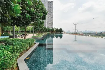 a swimming pool with water in front of a building at Ancestry 3BR M Vertica MRT Access by RumaBnB in Kuala Lumpur