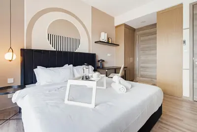 a bedroom with a large white bed with a table at Prestige 2BR Agile BB WiFi Netflix in Kuala Lumpur