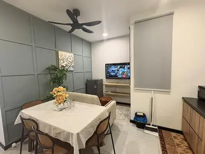 a dining room with a table and a tv at Neu Suites Apartments by LammyNora in Kuala Lumpur