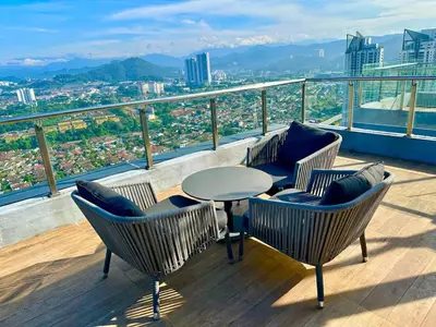 a patio with chairs and a table on a balcony at Neu Suites Apartments by LammyNora in Kuala Lumpur