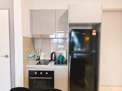 a kitchen with a black refrigerator and a sink at TRION POOL & KL City View The 110 Family Suite in Kuala Lumpur