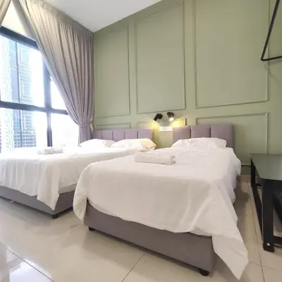 a bedroom with two beds and a desk and a window at TRION The 101 Family Suite Pool & KL City View in Kuala Lumpur