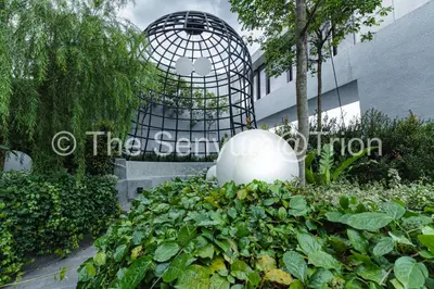 a bird cage in a garden in front of a building at TRION 2BR 6pax Ikea BBCC TRX Velocity KL Base 3KM in Kuala Lumpur