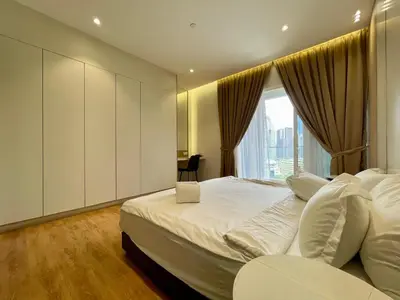 a bedroom with a large white bed with a window at Quill Comport Suits KLCC in Kuala Lumpur