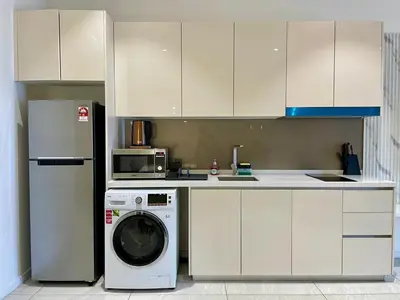 a kitchen with a washing machine and a microwave at Quill Comport Suits KLCC in Kuala Lumpur
