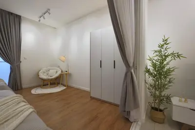 a bedroom with a bed and a chair and a mirror at Quill Comport Suits KLCC in Kuala Lumpur