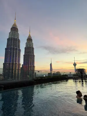 a group of people swimming in a pool with tall buildings at Star Residance KLCC by Nexus 84 in Kuala Lumpur