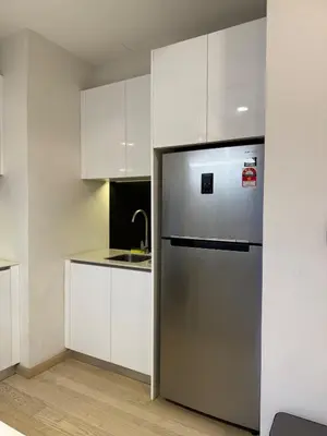 a kitchen with a stainless steel refrigerator and white cabinets at Star Residance KLCC by Nexus 84 in Kuala Lumpur